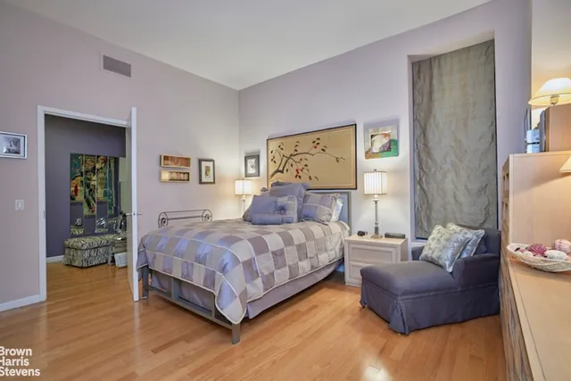 a spacious bedroom with a bed and a chandelier