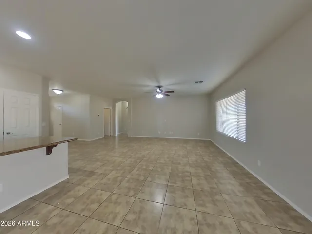 en empty room with windows and ceiling fan