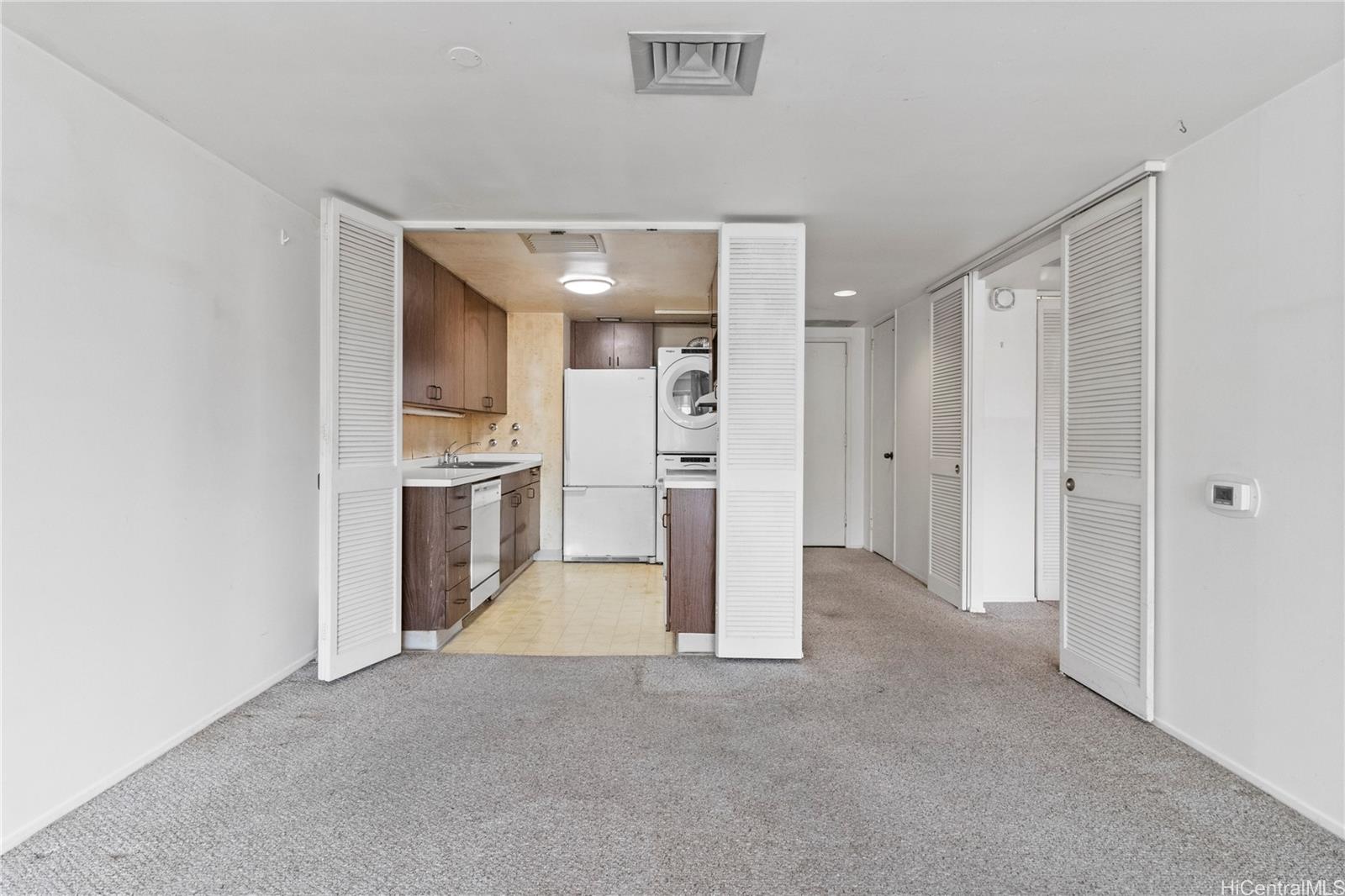 700 Richards Street, Unit 807 Honolulu, HI 96813 - Photo 5 of 15 a view of a kitchen with refrigerator and white cabinets