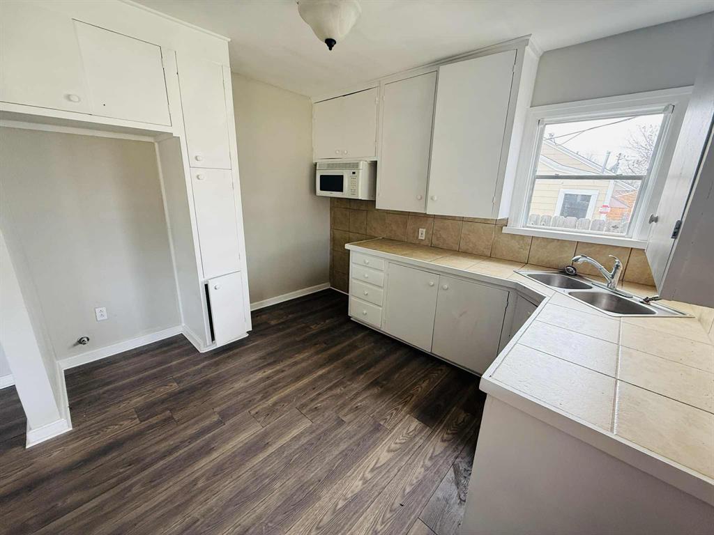 209 Hollywood Street Coleman, TX 76834 - Photo 11 of 19 a view of a kitchen with wooden floor and electronic appliances