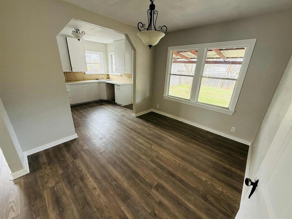 209 Hollywood Street Coleman, TX 76834 - Photo 13 of 19 wooden floor in an empty room with a window