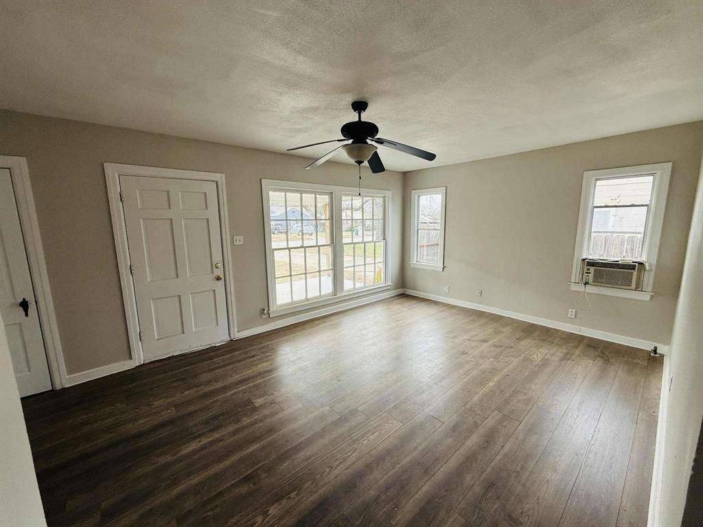 209 Hollywood Street Coleman, TX 76834 - Photo 15 of 19 a view of an empty room with wooden floor and a window