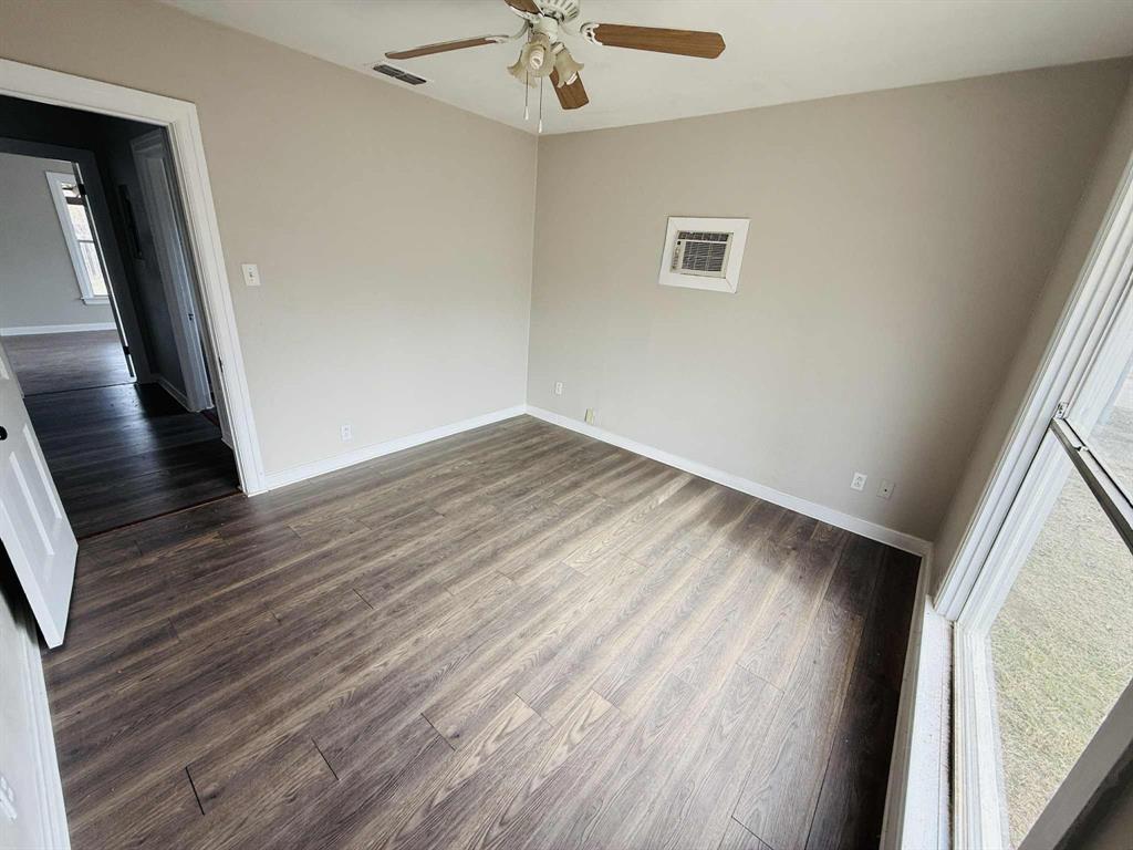 209 Hollywood Street Coleman, TX 76834 - Photo 16 of 19 wooden floor in an empty room with a window
