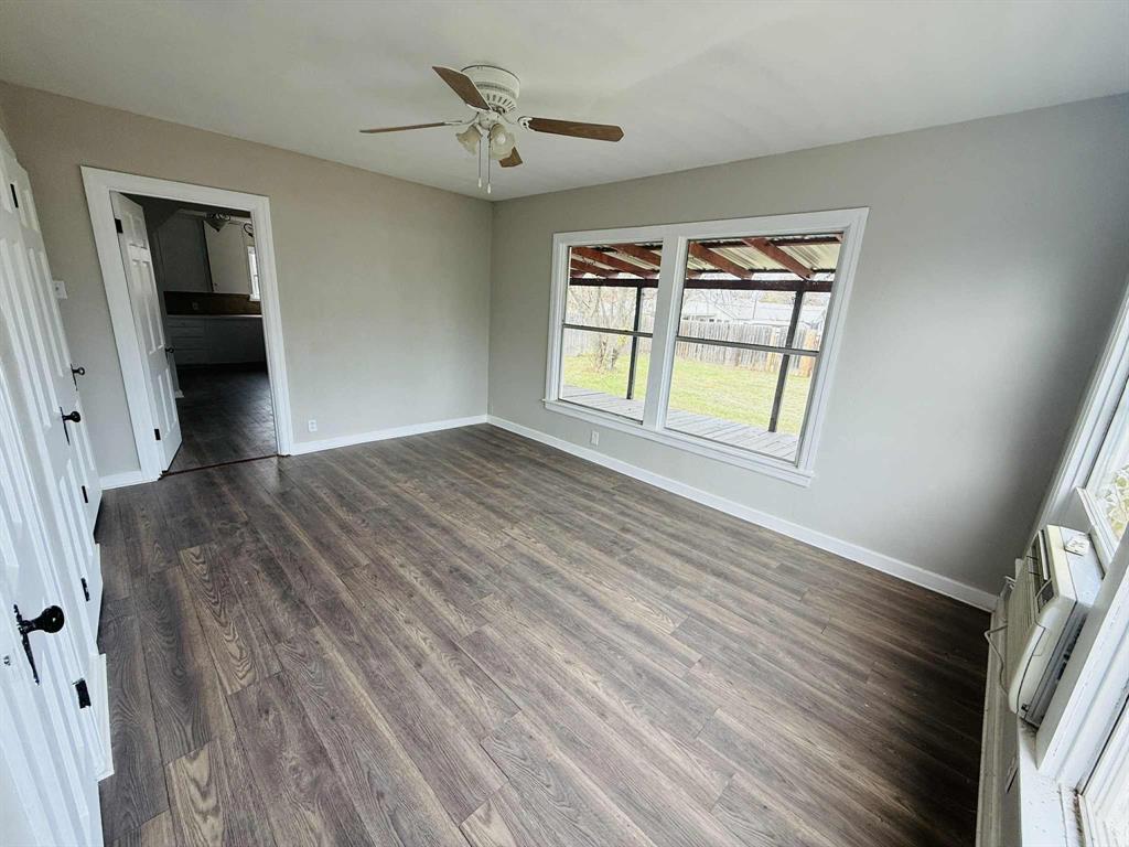 209 Hollywood Street Coleman, TX 76834 - Photo 18 of 19 a view of an empty room with a window and wooden floor