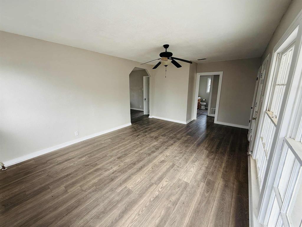 209 Hollywood Street Coleman, TX 76834 - Photo 19 of 19 a view of a livingroom with wooden floor and a ceiling fan