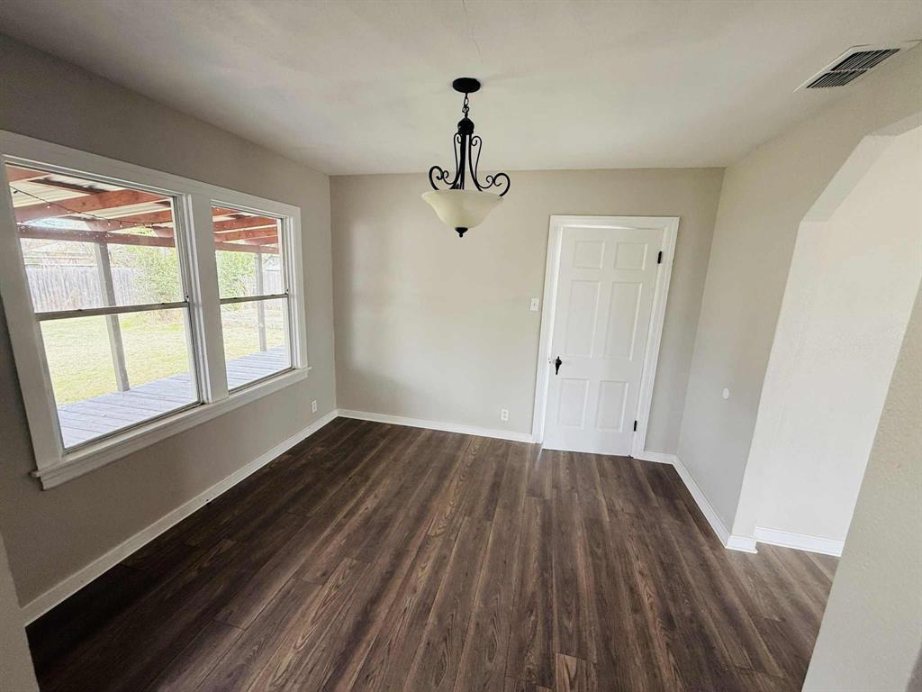 209 Hollywood Street Coleman, TX 76834 - Photo 9 of 19 a view of empty room with wooden floor and windows