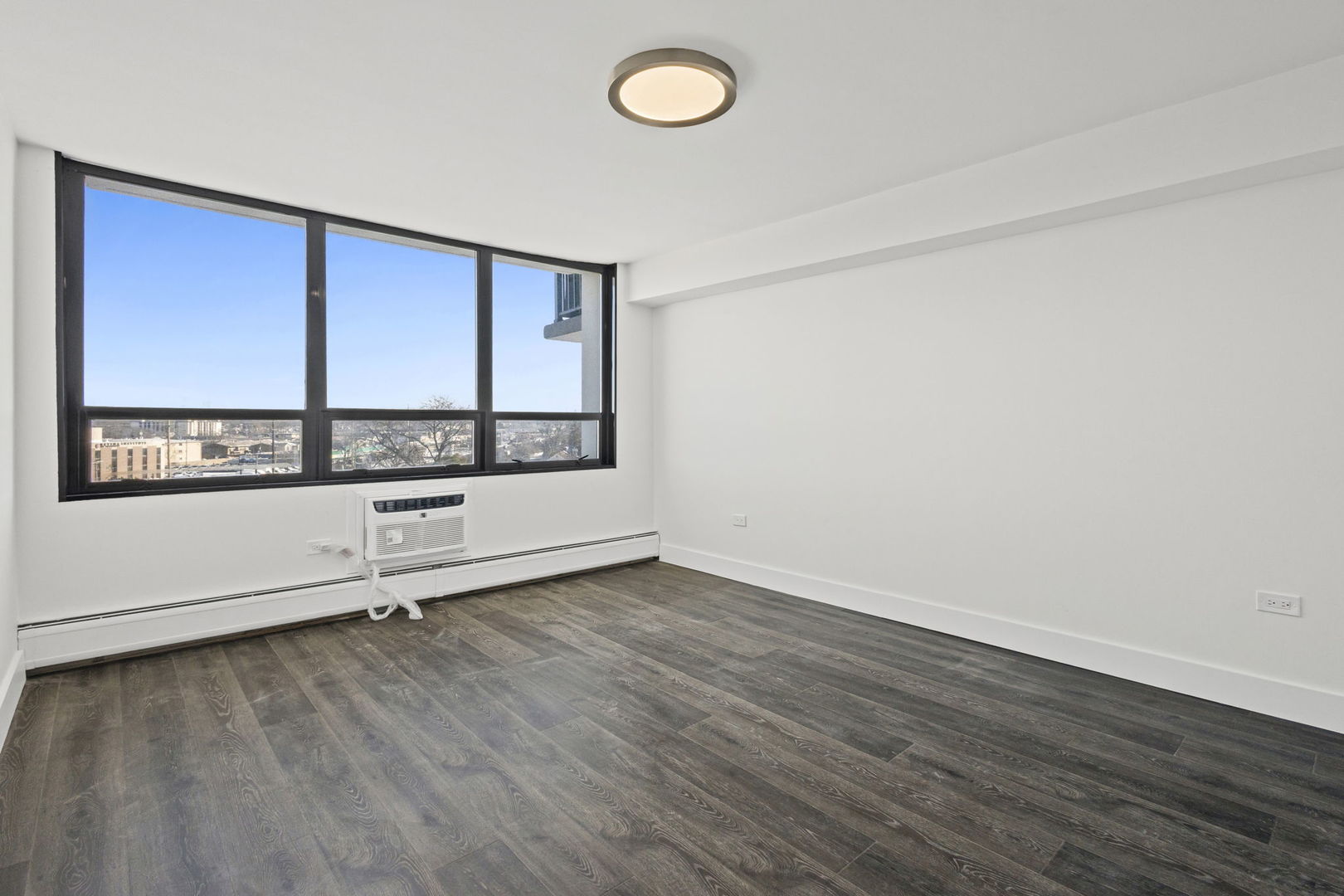 8801 West Golf Road, Unit 6E Niles, IL 60714 - Photo 14 of 15 an empty room with wooden floor and windows