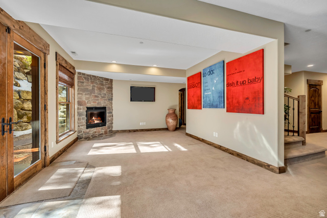 9049 Timphaven Road Sundance, UT 84604 - Photo 42 of 63 Unfurnished living room featuring light colored carpet and a stone fireplace