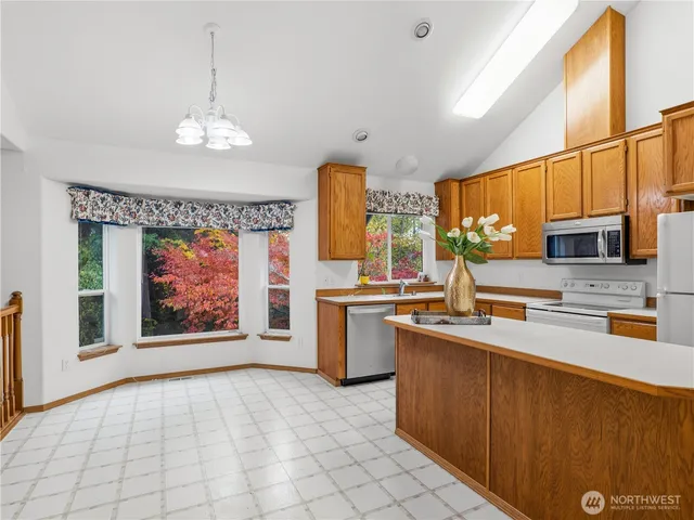 a kitchen with stainless steel appliances granite countertop a sink cabinets and window
