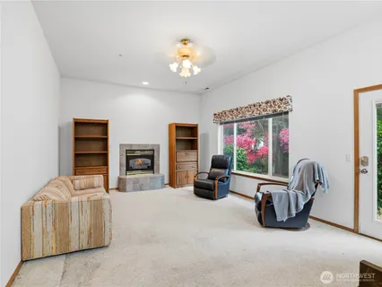 a living room with furniture a flat screen tv and kitchen view