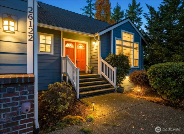 a view of a house with large windows and a yard