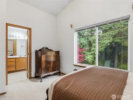a bedroom with a bed and a large window