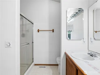 a bathroom with a sink a toilet and shower