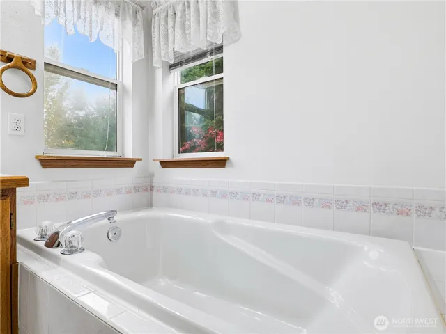 a bathroom with a bathtub and a window