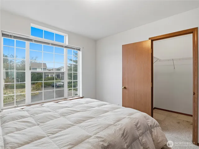 a bed sitting in a bedroom next to a window