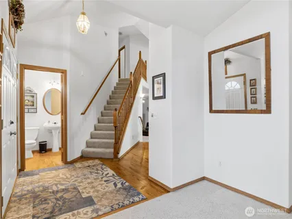 a view of a hallway with wooden floor and staircase