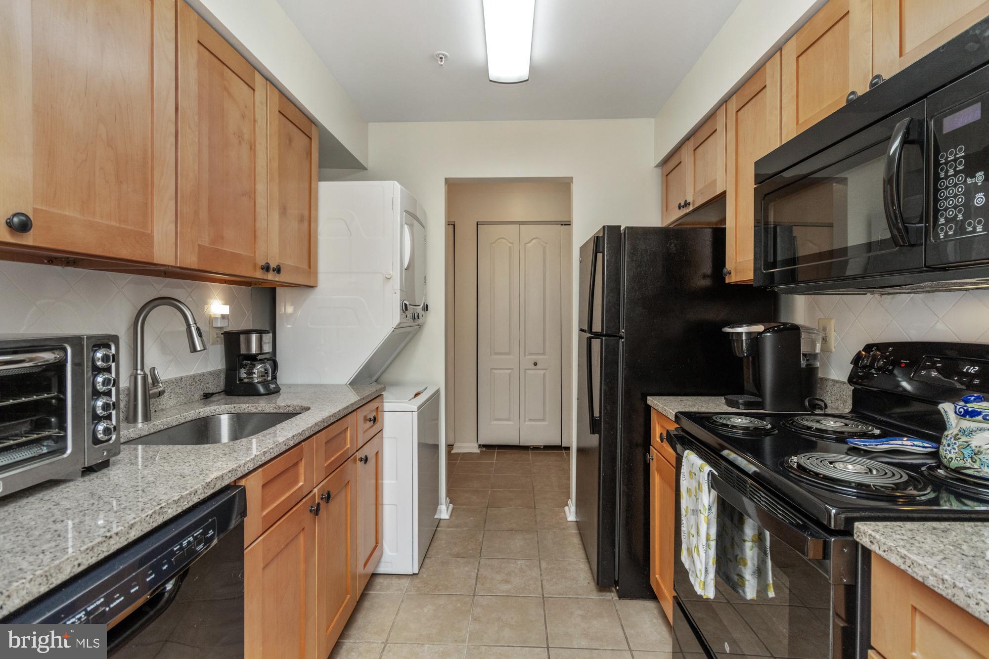8489 Falls Run Road, Unit B Ellicott City, MD 21043 - Photo 11 of 41 a kitchen with granite countertop a sink stove and refrigerator