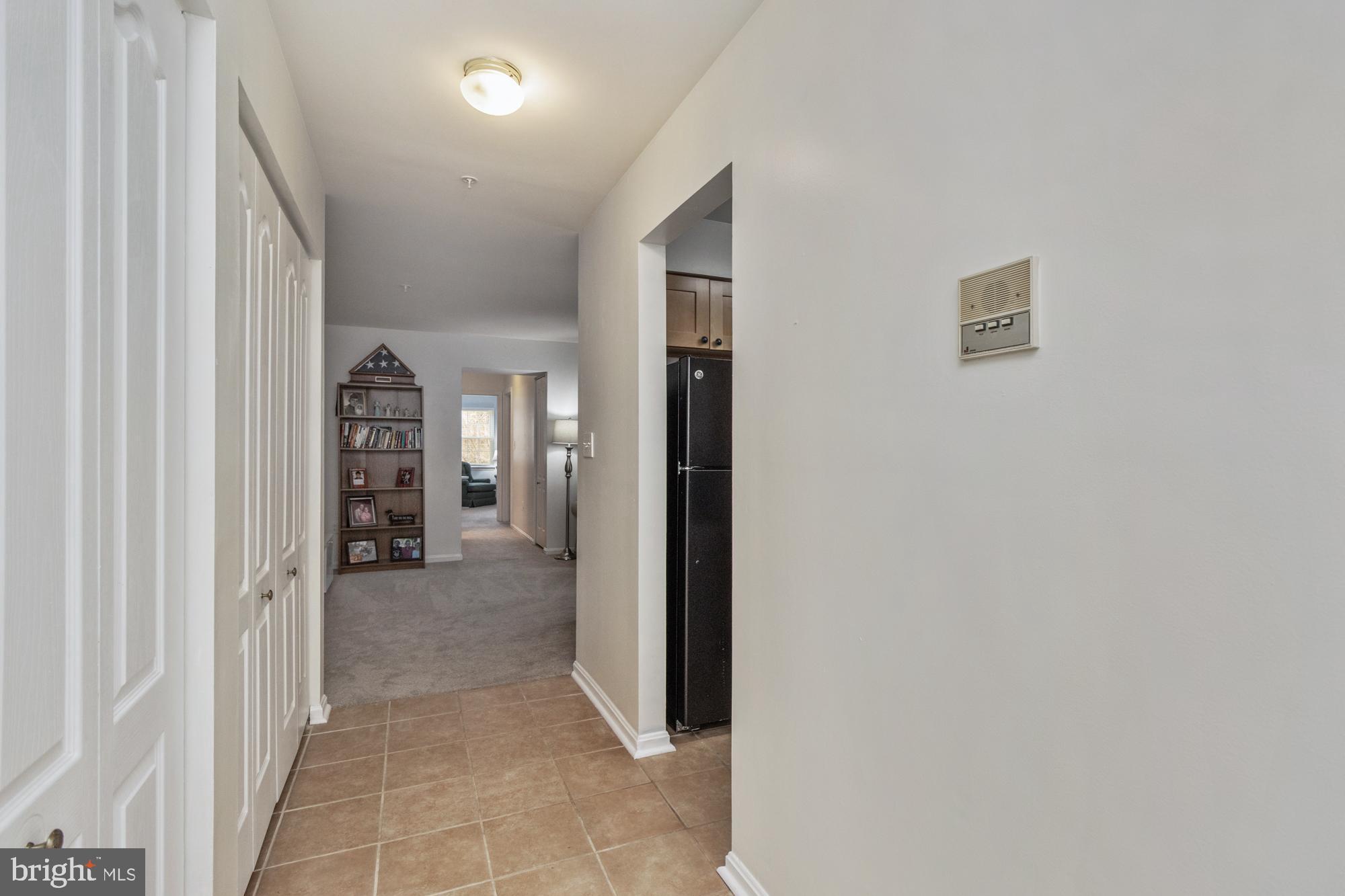 8489 Falls Run Road, Unit B Ellicott City, MD 21043 - Photo 6 of 41 a view of a hallway with wooden shelves