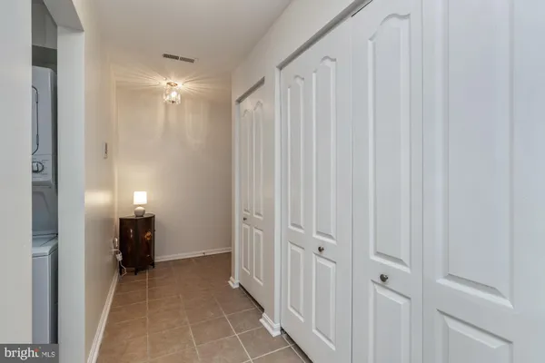 a view of a hallway with closet and a bathroom