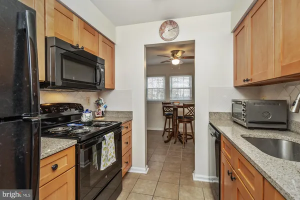 a kitchen with granite countertop a stove top oven microwave and cabinets