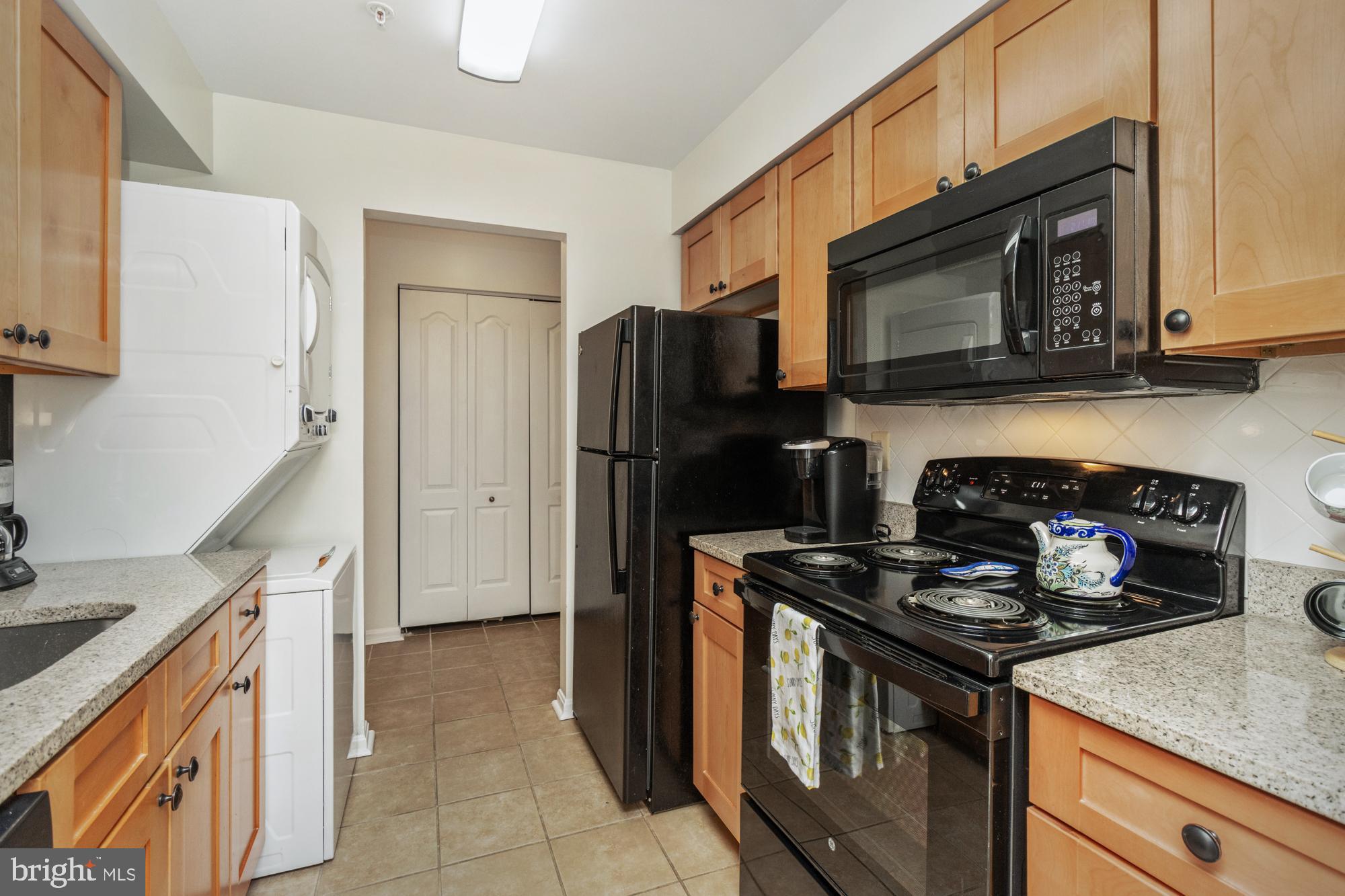 8489 Falls Run Road, Unit B Ellicott City, MD 21043 - Photo 10 of 41 a kitchen with stainless steel appliances granite countertop a stove microwave and refrigerator
