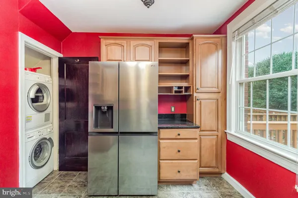 a kitchen with stainless steel appliances kitchen island granite countertop a refrigerator and a dresser