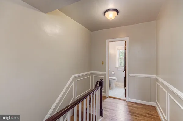 an empty room with wooden floor closet and windows