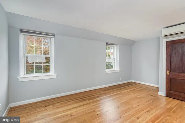 an empty room with wooden floor and entrance