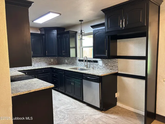 a kitchen with stainless steel appliances granite countertop wooden cabinets a refrigerator and a sink