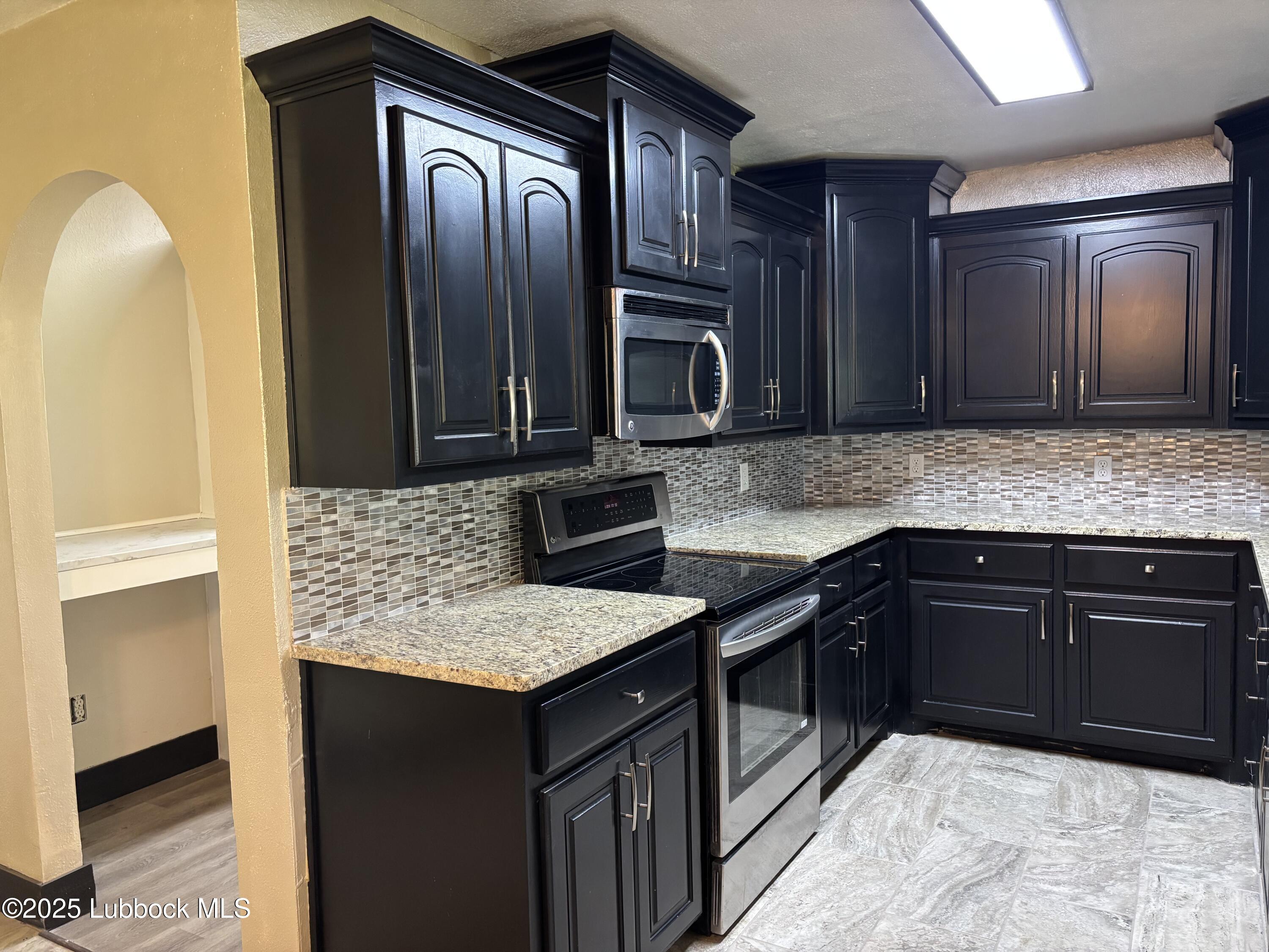 5 Parklane Drive Ransom Canyon, TX 79366 - Photo 13 of 30 a kitchen with stainless steel appliances granite countertop wooden cabinets a refrigerator and a sink