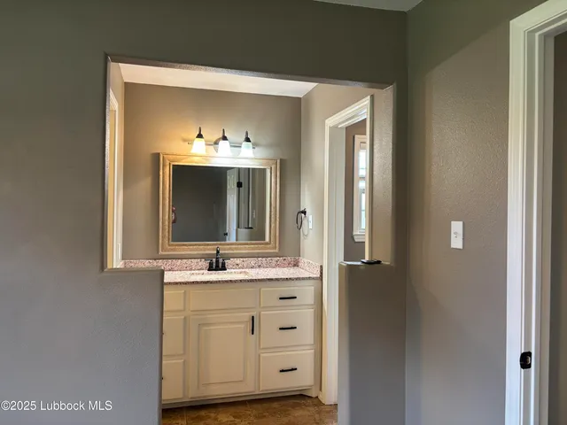 a bathroom with a granite countertop sink and a mirror
