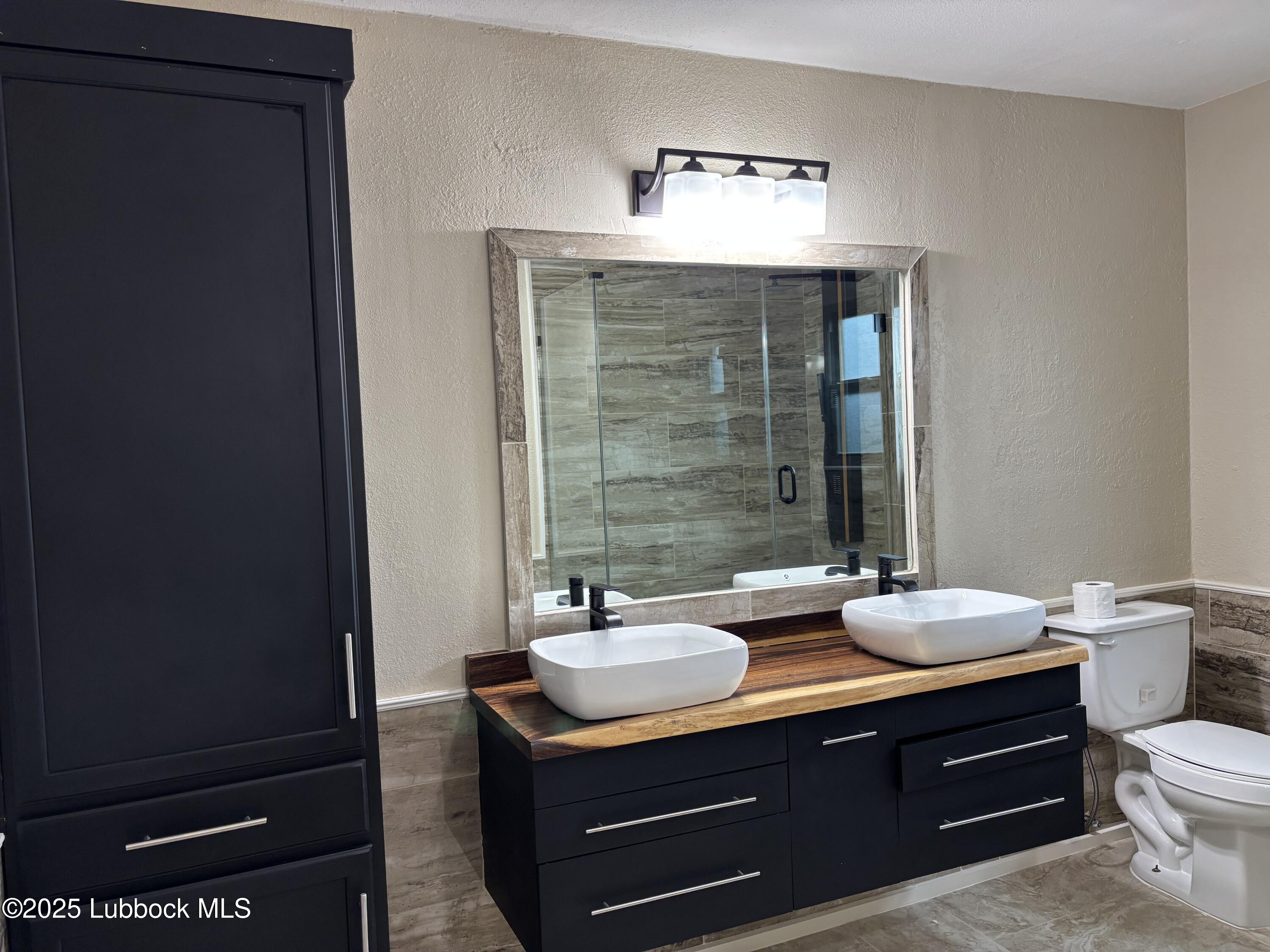 5 Parklane Drive Ransom Canyon, TX 79366 - Photo 27 of 30 a bathroom with a sink vanity and a mirror