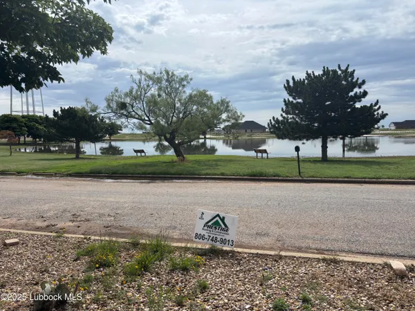 a lake view with a big yard and a fountain