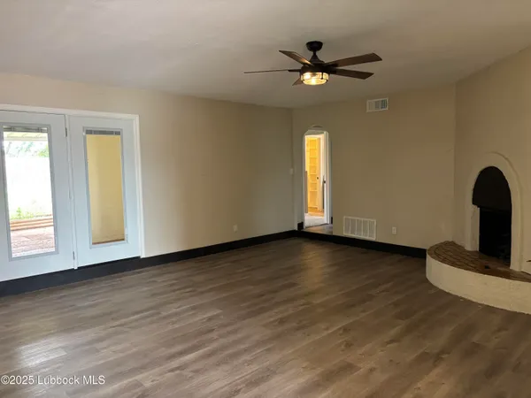 a view of a livingroom with wooden floor and a ceiling fan