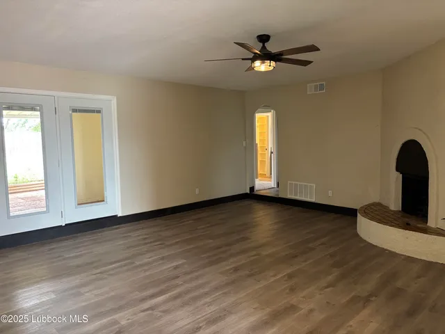 a view of a livingroom with wooden floor and a ceiling fan