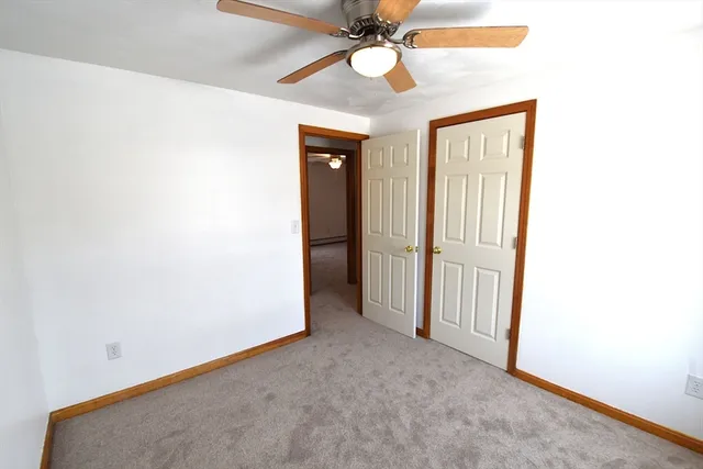 an empty room with a ceiling fan and wooden floor