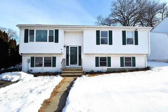 a front view of a house with a yard covered in snow