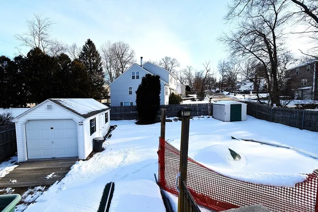 a view of a house with backyard and trees