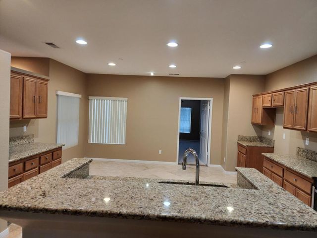 a kitchen with kitchen island granite countertop a sink stove and refrigerator