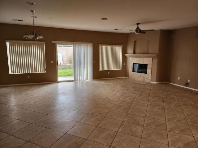 an empty room with windows and fireplace
