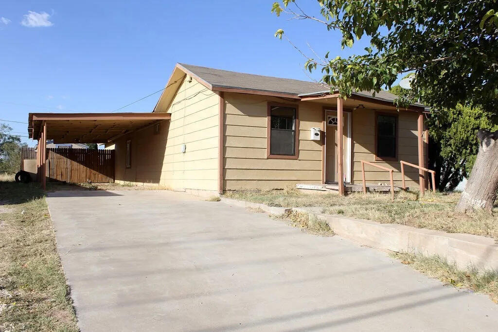 a view of house with backyard and trees