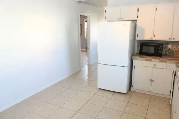 a white refrigerator freezer and a stove sitting inside of a kitchen