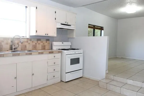a kitchen with granite countertop white cabinets and white appliances