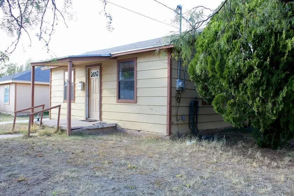 a view of a house with backyard and trees