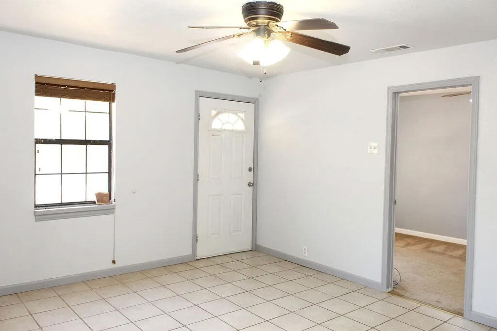 811 East 16th Street Big Spring, TX 79720 - Photo 4 of 20 an empty room with windows and fan