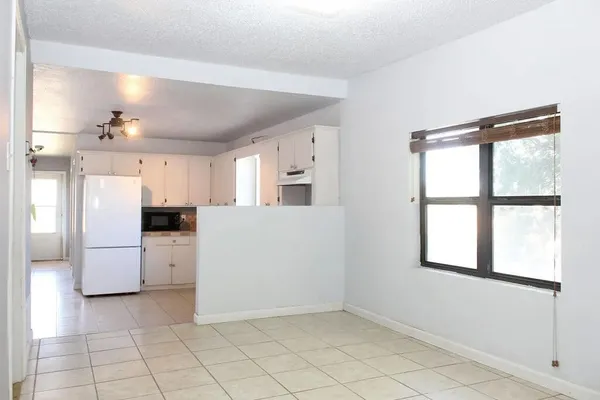 a view of kitchen with furniture and refrigerator