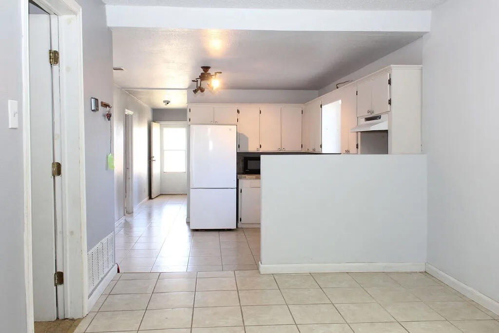 811 East 16th Street Big Spring, TX 79720 - Photo 10 of 20 a view of a refrigerator in kitchen and white cabinets