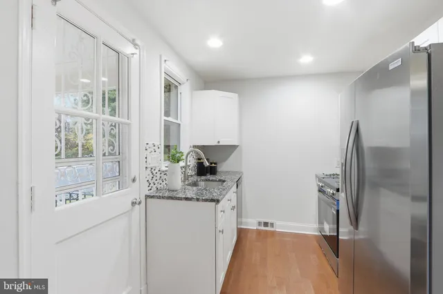 a kitchen with stainless steel appliances granite countertop a refrigerator and a sink
