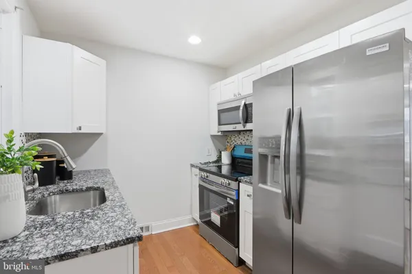 a kitchen with stainless steel appliances granite countertop a refrigerator and a sink