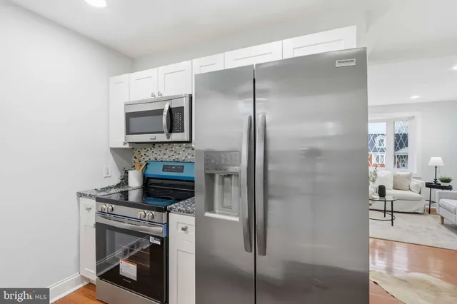 a kitchen with a refrigerator a microwave a stove and cabinets